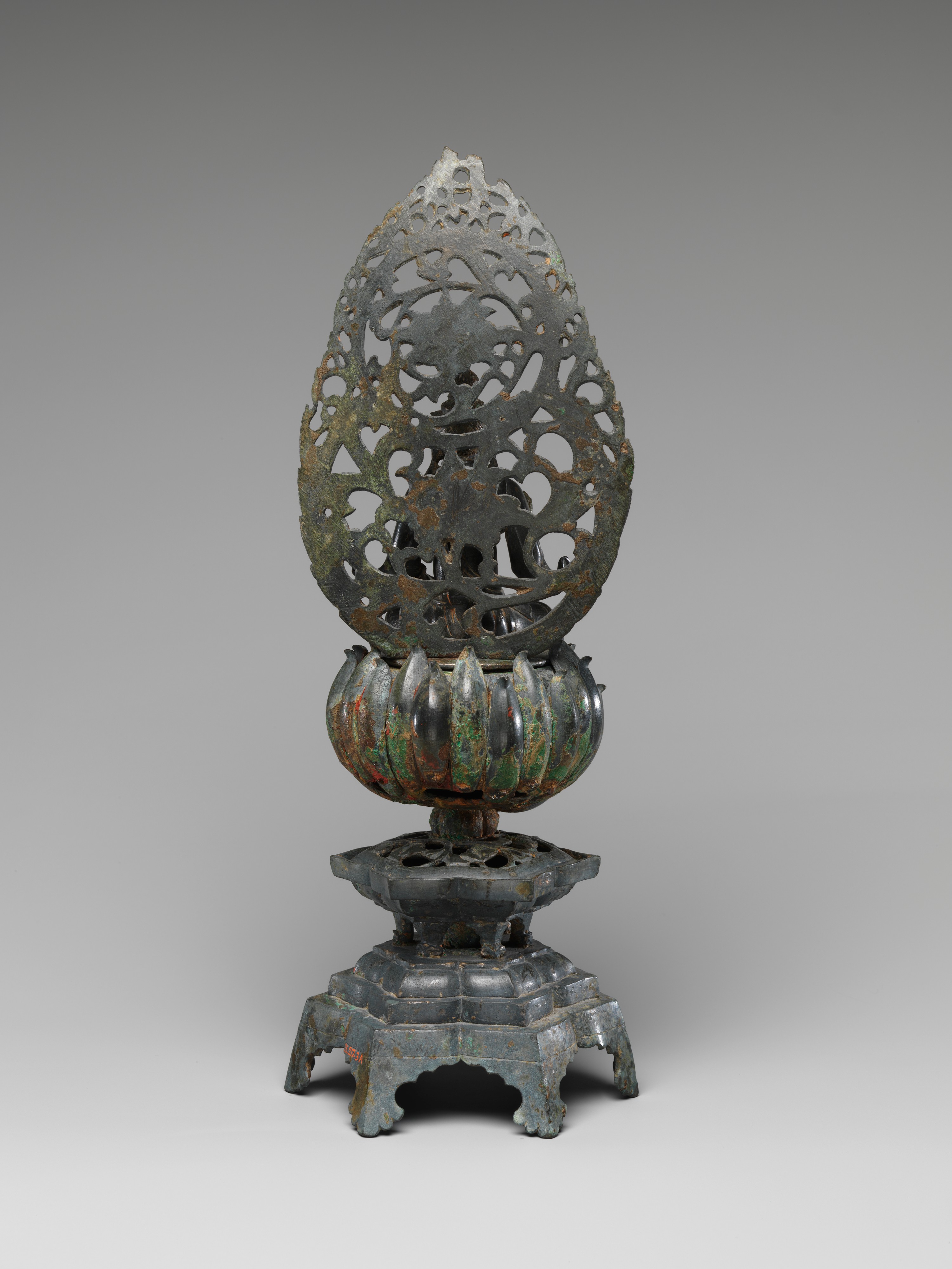 Back view of the bronze bodhisattva, showing the headdress, shoulders, long garment and lotus base.